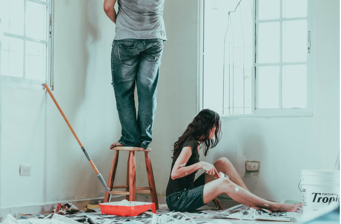 Man and woman painting walls white